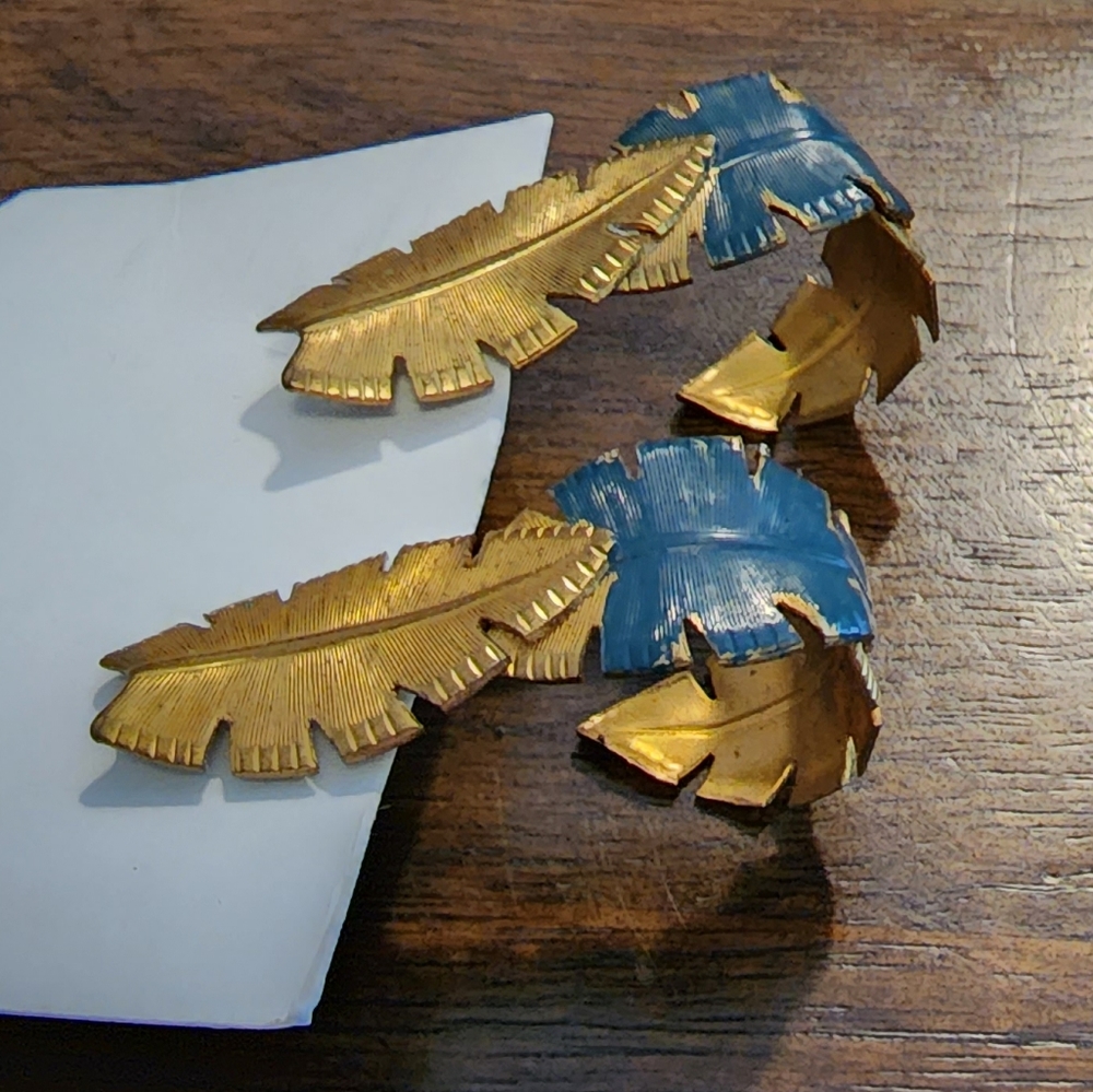 Gold green leaf earrings with a curve